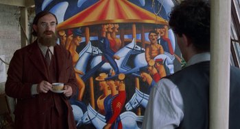 Movie still from “Carrington” (1995), directed by Christopher Hampton – A painting of a merry - go - round with people on it; Medium shot, Over the shoulder angle
