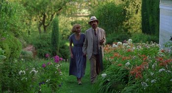 Movie still from “Carrington” (1995), directed by Christopher Hampton – A man and a woman are walking through a garden; Medium shot, Over the shoulder angle