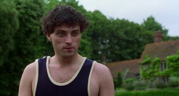 Movie still from “Carrington” (1995), directed by Christopher Hampton – A man with a beard and a black tank top; Close Up shot, Low angle