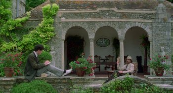 Movie still from “Carrington” (1995), directed by Christopher Hampton – Two men sitting on steps in front of a building; Wide shot, Low angle