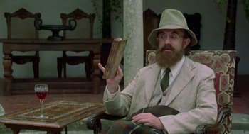Movie still from “Carrington” (1995), directed by Christopher Hampton – A man in a hat and glasses holding an open book; Medium shot, Low angle