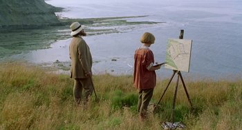 Movie still from “Carrington” (1995), directed by Christopher Hampton – A man and a woman are painting near a body of water; Wide shot, High angle