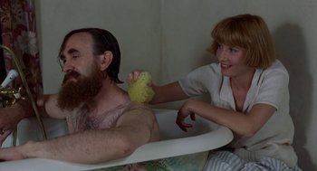 Movie still from “Carrington” (1995), directed by Christopher Hampton – A man sitting in a bath tub while a woman holds a sponge; Medium shot, High angle