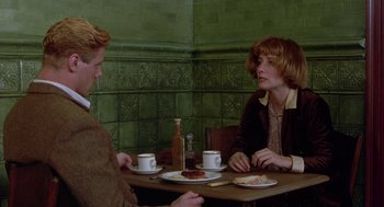 Movie still from “Carrington” (1995), directed by Christopher Hampton – A man and a woman sitting at a table with plates of food; Medium shot, Over the shoulder angle