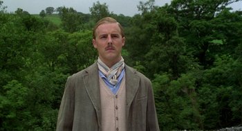 Movie still from “Carrington” (1995), directed by Christopher Hampton – A man with a mustache wearing a jacket and a neck tie; Close Up shot, Low angle