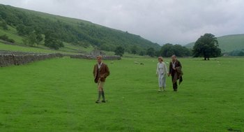 Movie still from “Carrington” (1995), directed by Christopher Hampton – A group of people walking across a lush green field; Wide shot, High angle