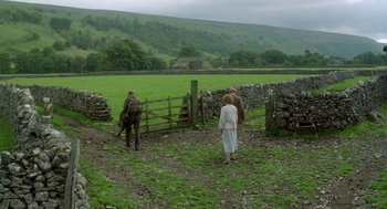 Movie still from “Carrington” (1995), directed by Christopher Hampton – Two women and a man are walking through a field; Extreme Wide shot, High angle