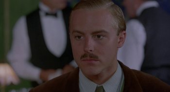 Movie still from “Carrington” (1995), directed by Christopher Hampton – A person wearing a suit and tie; Close Up shot, Low angle