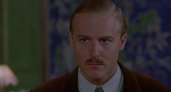 Movie still from “Carrington” (1995), directed by Christopher Hampton – A person wearing a suit and tie; Close Up shot, High angle