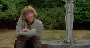 Movie still from “Carrington” (1995), directed by Christopher Hampton – A woman sitting on the ground holding a laptop; Medium shot, Low angle