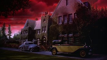 Movie still from “Cast a Deadly Spell” (1991), directed by Martin Campbell – An image of an old car parked in front of a building; Extreme Wide shot, Low angle