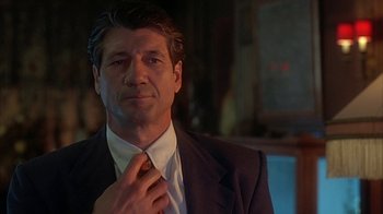 Movie still from “Cast a Deadly Spell” (1991), directed by Martin Campbell – A person wearing a suit and a tie; Close Up shot, Low angle