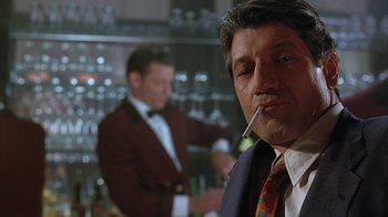 Movie still from “Cast a Deadly Spell” (1991), directed by Martin Campbell – A person smoking a cigarette in a bar; Close Up shot, Low angle