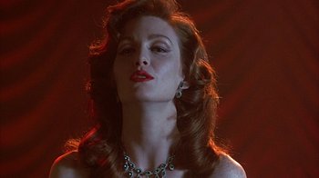 Movie still from “Cast a Deadly Spell” (1991), directed by Martin Campbell – A beautiful woman with red hair wearing a necklace; Close Up shot, Low angle