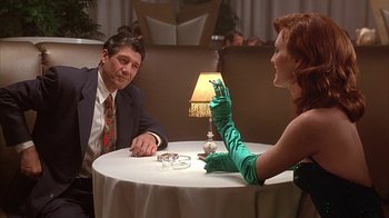 Movie still from “Cast a Deadly Spell” (1991), directed by Martin Campbell – A man and a woman sitting at a dinner table; Medium shot, Low angle