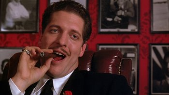 Movie still from “Cast a Deadly Spell” (1991), directed by Martin Campbell – A person wearing a suit and tie; Close Up shot, Low angle