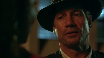 Movie still from “Cast a Deadly Spell” (1991), directed by Martin Campbell – A person wearing a hat; Close Up shot, Over the shoulder angle