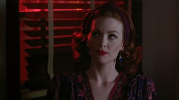 Movie still from “Cast a Deadly Spell” (1991), directed by Martin Campbell – A woman with red hair and a purple head band; Close Up shot, Over the shoulder angle