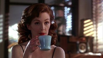 Movie still from “Cast a Deadly Spell” (1991), directed by Martin Campbell – A beautiful woman holding a blue cup in her hand; Close Up shot, Over the shoulder angle