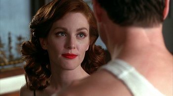 Movie still from “Cast a Deadly Spell” (1991), directed by Martin Campbell – A woman with red lipstick looking at a man in a white suit; Close Up shot, Over the shoulder angle