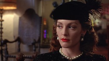 Movie still from “Cast a Deadly Spell” (1991), directed by Martin Campbell – A person wearing pearls and a hat; Close Up shot, Over the shoulder angle