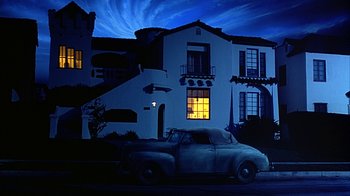 Movie still from “Cast a Deadly Spell” (1991), directed by Martin Campbell – An old truck parked in front of a white house at night; Extreme Wide shot, Low angle