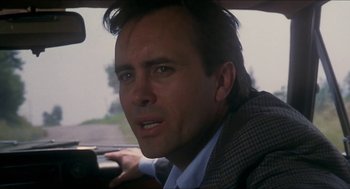 Movie still from “Castle Freak” (1995), directed by Stuart Gordon – A person sitting in a car; Close Up shot, Low angle