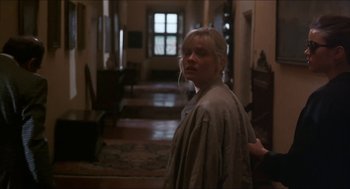 Movie still from “Castle Freak” (1995), directed by Stuart Gordon – A woman standing in a room with a door open; Medium shot, Over the shoulder angle