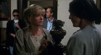 Movie still from “Castle Freak” (1995), directed by Stuart Gordon – A woman standing in front of two other people; Medium shot, Over the shoulder angle