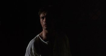 Movie still from “Castle Freak” (1995), directed by Stuart Gordon – A man in a white shirt standing in the dark; Close Up shot, Low angle