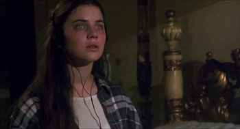 Movie still from “Castle Freak” (1995), directed by Stuart Gordon – A woman with a plaid shirt and headphones; Close Up shot, High angle