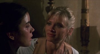 Movie still from “Castle Freak” (1995), directed by Stuart Gordon – A woman sitting next to another woman in a room; Close Up shot, Over the shoulder angle