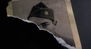 Movie still from “Castle Freak” (1995), directed by Stuart Gordon – An old photo of a man in a military hat; Extreme Close Up shot, Overhead angle