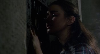 Movie still from “Castle Freak” (1995), directed by Stuart Gordon – A young woman leaning up against a wall with her eyes closed; Close Up shot, High angle