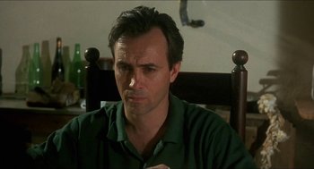 Movie still from “Castle Freak” (1995), directed by Stuart Gordon – A person sitting in a chair; Close Up shot, Low angle