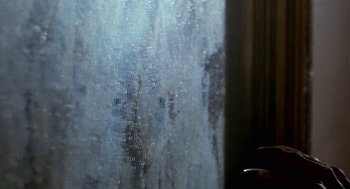 Movie still from “Castle Freak” (1995), directed by Stuart Gordon – A window that has water on the outside of it; Extreme Close Up shot, Low angle
