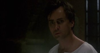 Movie still from “Castle Freak” (1995), directed by Stuart Gordon – A person wearing a white t - shirt; Close Up shot, Low angle