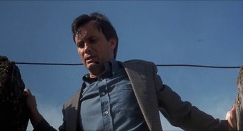 Movie still from “Castle Freak” (1995), directed by Stuart Gordon – A person wearing a suit and tie; Medium shot, Low angle
