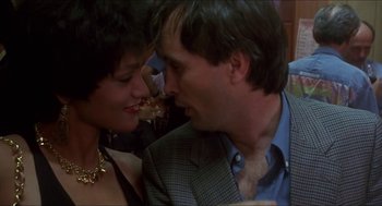 Movie still from “Castle Freak” (1995), directed by Stuart Gordon – A man and a woman kissing each other in front of a crowd; Close Up shot, Low angle