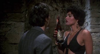 Movie still from “Castle Freak” (1995), directed by Stuart Gordon – A woman holding a bottle of beer next to a man; Close Up shot, Over the shoulder angle