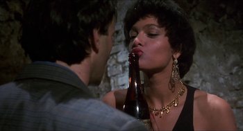 Movie still from “Castle Freak” (1995), directed by Stuart Gordon – A man and a woman are kissing while holding a beer; Close Up shot, Over the shoulder angle