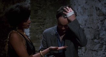 Movie still from “Castle Freak” (1995), directed by Stuart Gordon – A man and a woman holding their hands over their head; Medium shot, High angle