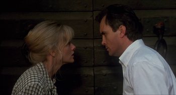 Movie still from “Castle Freak” (1995), directed by Stuart Gordon – A man and a woman face to face in front of a wooden wall; Close Up shot, Low angle