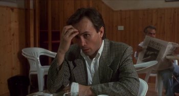 Movie still from “Castle Freak” (1995), directed by Stuart Gordon – A man sitting at a table with his head in his hand; Close Up shot, Over the shoulder angle