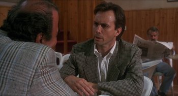 Movie still from “Castle Freak” (1995), directed by Stuart Gordon – A man in a suit talking to another man in a plaid jacket; Close Up shot, Over the shoulder angle