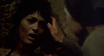 Movie still from “Castle Freak” (1995), directed by Stuart Gordon – A person is holding a hand up to a woman's face; Close Up shot, Over the shoulder angle