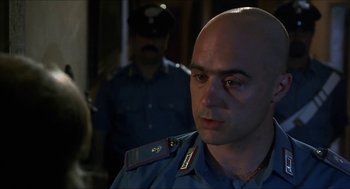 Movie still from “Castle Freak” (1995), directed by Stuart Gordon – A man in a police uniform looking at the camera; Close Up shot, Over the shoulder angle