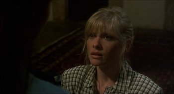 Movie still from “Castle Freak” (1995), directed by Stuart Gordon – A woman with blonde hair and a checkered shirt looking to her left; Close Up shot, Over the shoulder angle