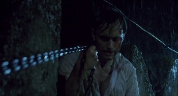 Movie still from “Castle Freak” (1995), directed by Stuart Gordon – A man holding a chain in a dark room; Close Up shot, Low angle
