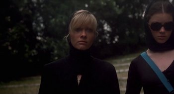 Movie still from “Castle Freak” (1995), directed by Stuart Gordon – A woman in a black jacket standing in front of a tree; Close Up shot, Low angle